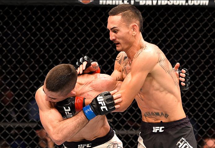 Max Holloway punches Ricardo Lamas during their featherweight bout at UFC 199