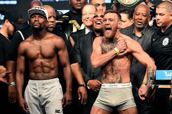 LAS VEGAS, NV - AUGUST 25: Boxer Floyd Mayweather Jr. (L) and UFC lightweight champion Conor McGregor face off during their official weigh-in at T-Mobile Arena on August 25, 2017 in Las Vegas, Nevada. The two will meet in a super welterweight boxing match at T-Mobile Arena on August 26. (Photo by Jeff Bottari/Zuffa LLC)