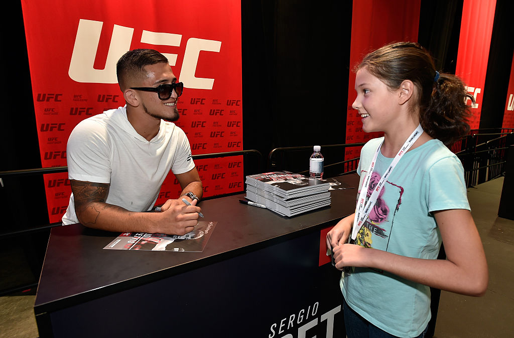 LAS VEGAS, NV - JULY 08: Mixed martial artist Sergio Pettis (L) meets with a young fan at the UFC Fan Expo at the Las Vegas Convention Center on July 8, 2016 in Las Vegas, Nevada. (Photo by David Becker/Zuffa LLC)