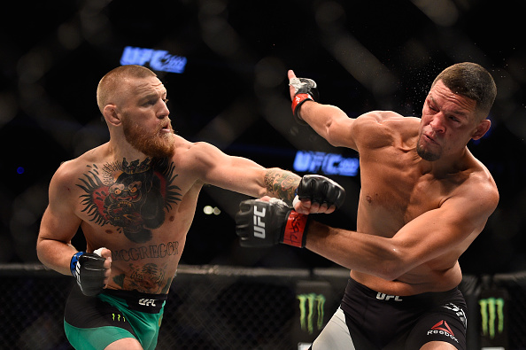 Conor McGregor punches Nate Diaz during their rematch at UFC 202