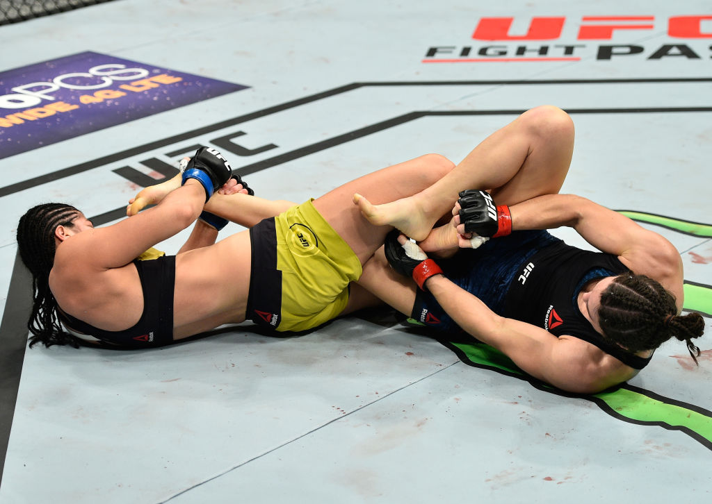 EDMONTON, AB - SEPTEMBER 09: (L-R) <a href='../fighter/ketlen-vieira'>Ketlen Vieira</a> of Brazil attempts to submit <a href='../fighter/Sara-McMann'>Sara McMann</a> in their women’s bantamweight bout during the UFC 215 event inside the Rogers Place on September 9, 2017 in Edmonton, Alberta, Canada. (Photo by Jeff Bottari/Zuffa LLC)“ align=“center“/>Unbeaten rising bantamweight star Ketlen Vieira scored the biggest win of her career in UFC 215 prelim action, as she submitted Sara McMann in the second round at Rogers Place in Edmonton.</p><p>Not surprisingly, McMann put Vieira (9-0) on the deck early and the Olympic silver medalist went to work, eventually getting the mount position, where she fired off punches. Vieira was able to get loose though, and she soon had McMann in trouble as she tried to lock a leg up. But McMann broke free just before the end of the round.</p><p>As McMann (11-4) shot for a takedown in the second minute of round two, Vieira was able to land some hard close-range shots that ended that attempt. McMann recovered quickly and worked from the clinch, but it was Vieira getting the takedown with two minutes left. As the round wore down, Viera suddenly locked in an arm triangle choke, and McMann was forced to tap out at 4:16 of the second stanza.</p><p><strong>MORAS vs EVANS-SMITH</strong></p><blockquote class=
