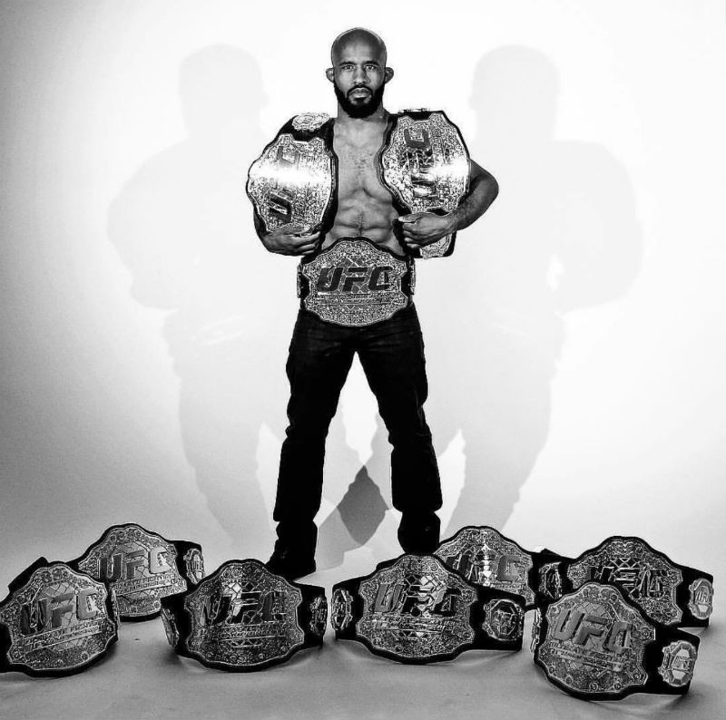 Demetrious Johnson poses with the 10 UFC championship belts he has won during his fight-career