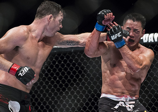 Michael Bisping (L) of England punches Cung Le of USA during their 5-Round middleweight fight during the UFC Fight Night at The Venetian Macao Cotai Arena on August 23, 2014 in Macau, China. (Photo by Victor Fraile/Getty Images)
