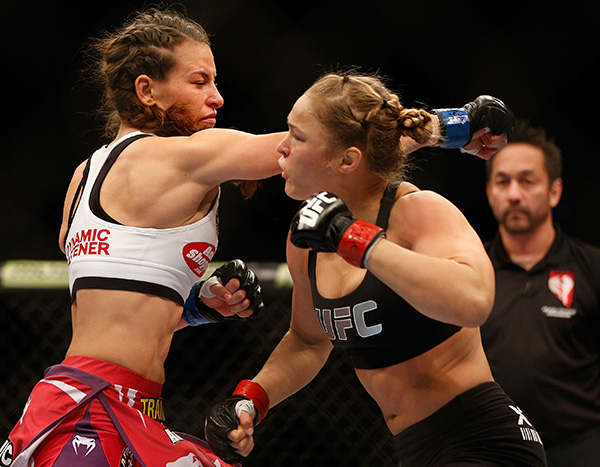 (L-R) Miesha Tate punches Ronda Rousey in their UFC women's bantamweight championship bout during UFC 168 event at the MGM Grand Garden Arena on December 28, 2013 in Las Vegas, Nevada. (Photo by Josh Hedges/Zuffa LLC)