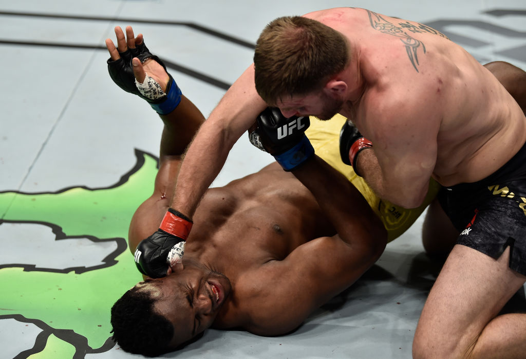 Stipe Miocic punches Francis Ngannou during their heavyweight title fight at UFC 220