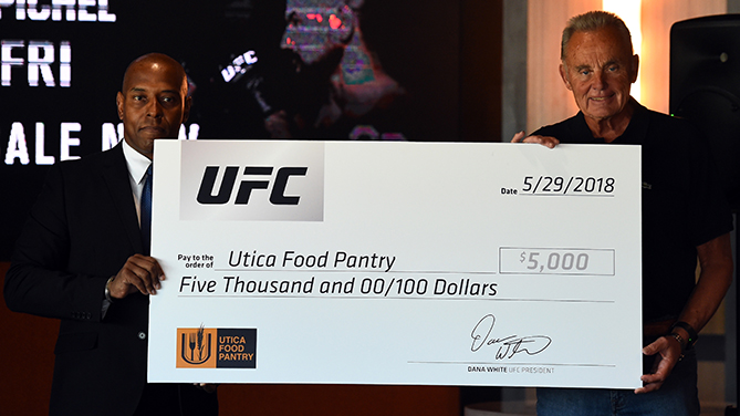 UTICA, NY - MAY 29: (L-R) UFC senior director of communications Dave Lockett presents a donation to Russell Brooks, president of the Utica Food Pantry, during a UFC press conference at the Adirondack Bank Center on May 29, 2018 in Utica, New York. (Photo by Josh Hedges/Zuffa LLC/Zuffa LLC via Getty Images)