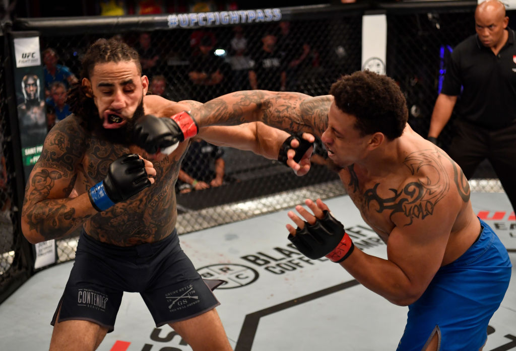 Greg Hardy punches Austen Lane in their heavyweight bout during Dana White's Tuesday Night Contender Series at the TUF Gym on June 12, 2018 in Las Vegas, Nevada. (Photo by Jeff Bottari/DWTNCS LLC)