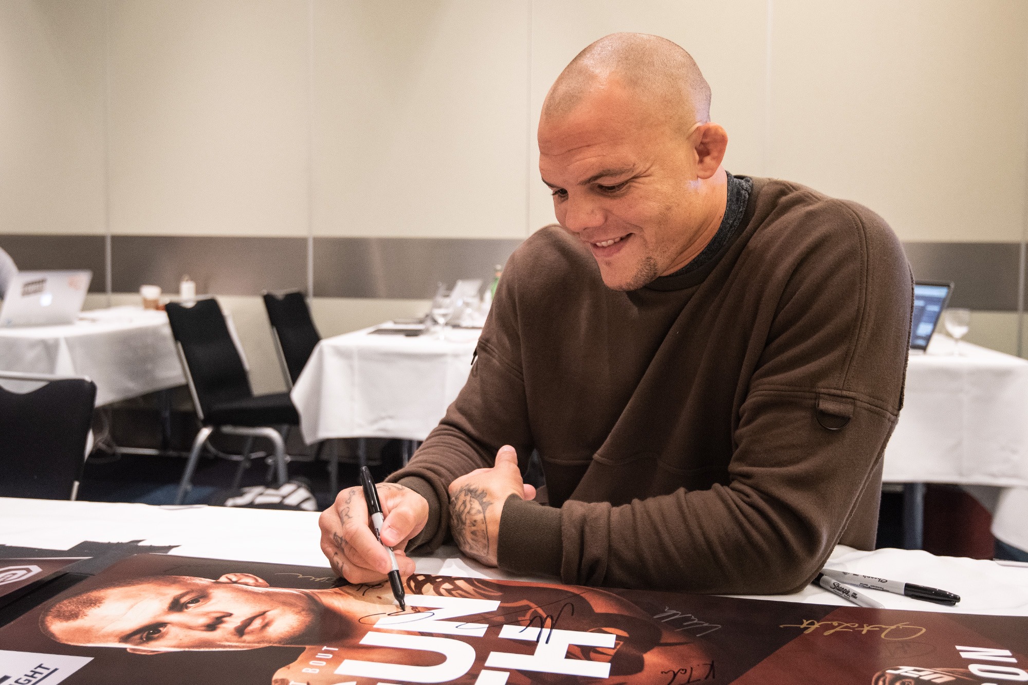 Smith signs posters at Fight Night Hamburg check-ins, 2018.