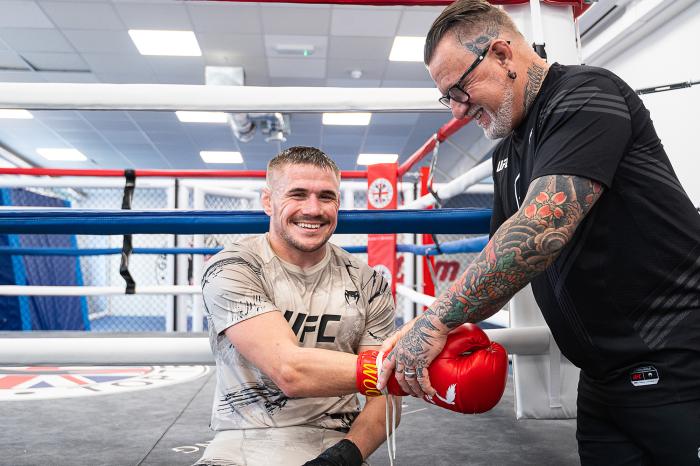 Nathaniel Wood takes off his boxing gloves with the help of his dad, Gary Wood inside Great Britain Top Team In Mitcham, South London, United Kingdom. (Photo by John Barry/Zuffa LLC)